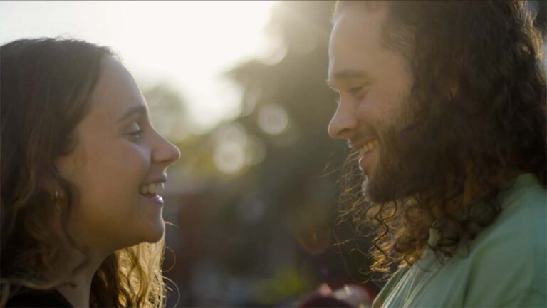 Photo of young woman and man smiling at each other lovingly